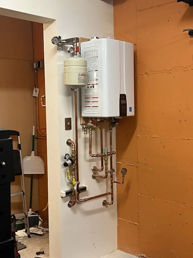 Plumbing technician inspecting water heater connections in Burns